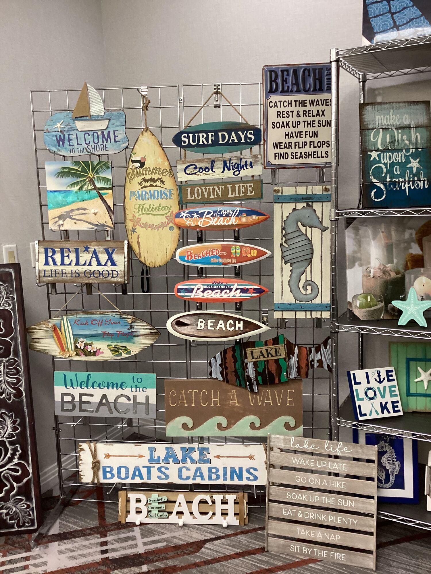 Coastal and lake decor signs from Top Notch Products on a showroom display wall